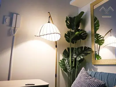 a room with a lamp and a vase with a plant at Cozy Vibrant Staycation Netflix Wifi Mandaluyong in Manila