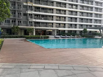 a swimming pool in front of a large building at Cozy Vibrant Staycation Netflix Wifi Mandaluyong in Manila