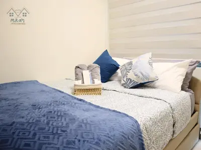 a bed with blue and white sheets and pillows at Cozy Vibrant Staycation Netflix Wifi Mandaluyong in Manila