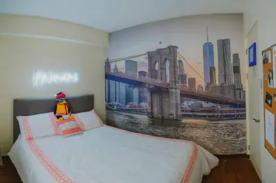 a bedroom with a painting of a bridge on the wall at The One with Purple Apartment in Manila