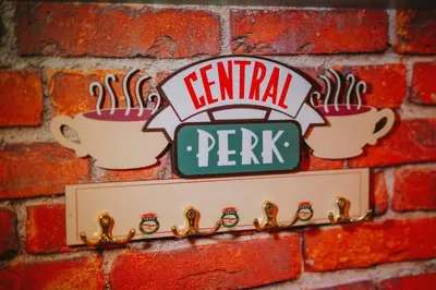 a sign on a brick wall with two cups of coffee at The One with Purple Apartment in Manila