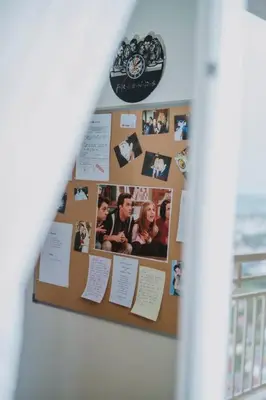 a bulletin board with photos and papers on it at The One with Purple Apartment in Manila