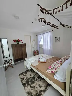 a bedroom with a large bed and a dresser in it at Vintage charm meets modern relaxation near Araneta in Manila
