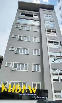 a tall building with a sign on the side of it at Vintage charm meets modern relaxation near Araneta in Manila