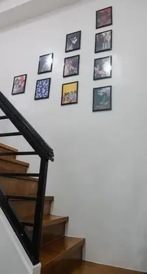 a wall of pictures on a stairwell at Modern Condo for 6, with Kitchen, Wi-Fi & Netflix, Near MRT Boni in Manila