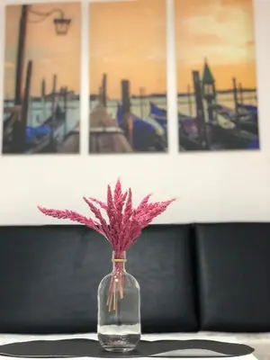 a glass vase with a pink plant in it at Metro Suites in Anabu Primero