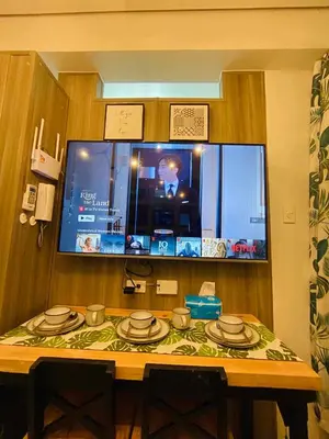 a table with plates and a tv in a room at Coast Stay by J 41st floor Penthouse in Manila
