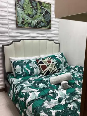 a bed with green and white sheets and pillows at Coast Stay by J 41st floor Penthouse in Manila