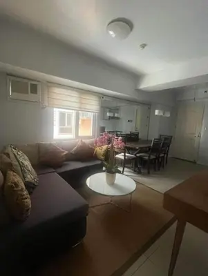 a living room with a couch and a table at Avida San lorenzo Tower 1 in Manila