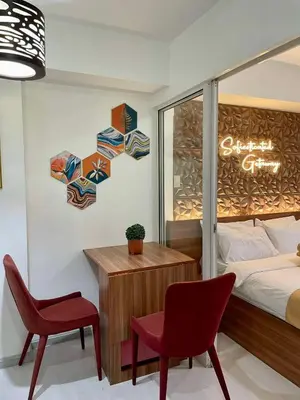 a bedroom with a bed and a desk and a chair at 1 Bedroom Azure Staycation Near NAIA in Manila