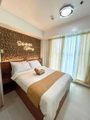 a bedroom with a large bed with a chandelier at 1 Bedroom Azure Staycation Near NAIA in Manila