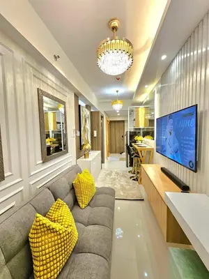 a living room with a couch and a tv at Skyport Luxe in Manila