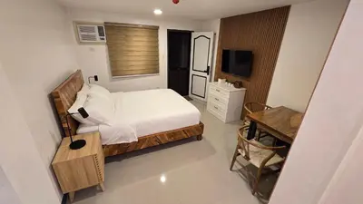 a bedroom with a bed and a table and a desk at Flat 35, Unit 1F in Manila