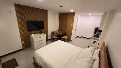 a bedroom with a bed and a flat screen tv at Flat 35, Unit 1F in Manila