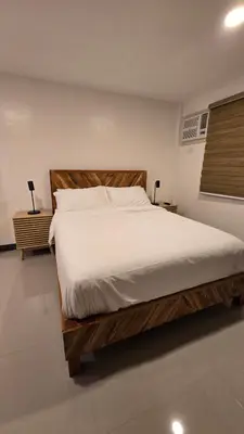 a bedroom with a large bed with white sheets at Flat 35, Unit 1F in Manila