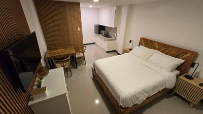 a bedroom with a bed and a table and a television at Flat 35, Unit 1F in Manila