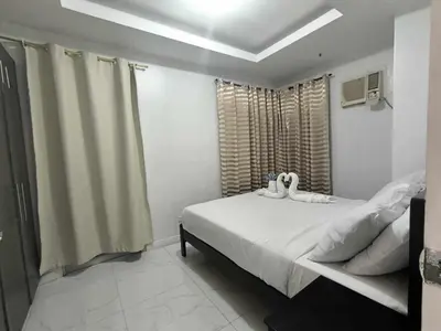 a bedroom with a bed with two stuffed animals on it at Explore Manila Trendy 1BR unit in Birch Tower in Manila