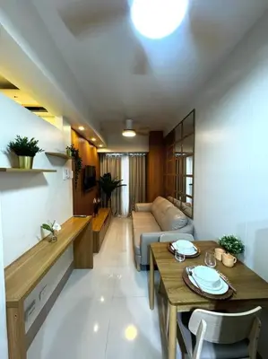 a living room with a table and a couch at Shore 3 katkat staycation in Manila