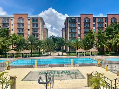 a swimming pool in front of a large building at Tiaras Luxury Condotel in Manila
