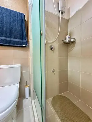 a small bathroom with a shower and a toilet at Marias Crib in Manila