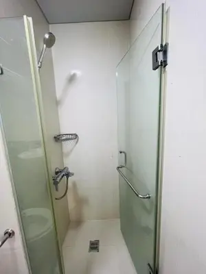 a bathroom with a shower with a glass door at One palm tree villas &Two palm tree villas in Manila
