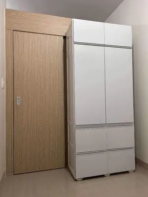 a white refrigerator next to a wooden cabinet at Newly build Condo Minimalist Charm in Manila