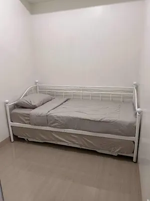 a bed in a room with a white wall at Newly build Condo Minimalist Charm in Manila