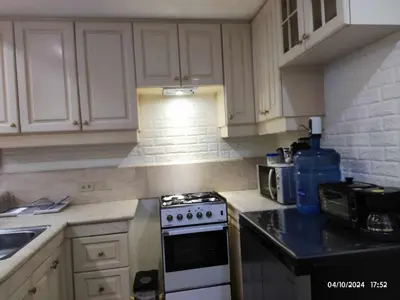 a kitchen with white cabinets and a stove top oven at Condo With Balcony And Bayview In Malate, Manila in Manila