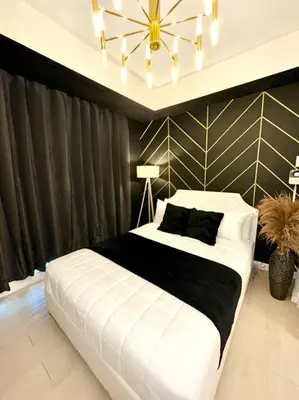 a bedroom with a large white bed and a chandelier at Azure 1BR with Projector in Manila