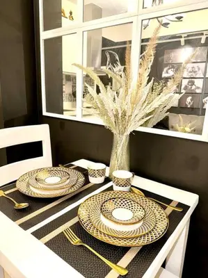 a table with plates and utensils on top of it at Azure 1BR with Projector in Manila