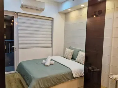 a bed with a teddy bear on it in a room at Cozy retreat w Balcony, Netflix, 100 mbps internet, Pool, near BGC in Manila