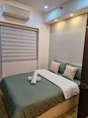 a bed with a stuffed animal sitting on top of it at Cozy retreat w Balcony, Netflix, 100 mbps internet, Pool, near BGC in Manila