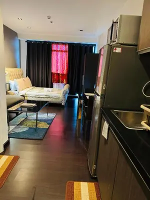 a living room with a kitchen and a living room with a couch at Gramercy Residences Studio with balcony Near Airport in Manila