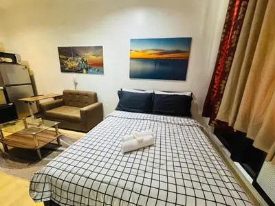 a bedroom with a bed and a chair at Gramercy Residences Studio with balcony Near Airport in Manila