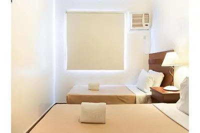 a hotel room with two beds and a window at Townhouse OAK Metro Manila Near Osmena Highway PNR Pasay formerly Avitel Hotel in Manila