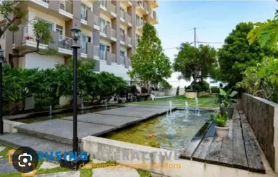 a courtyard with a pond in front of a building at Affordable & Spacious Condo in Makati in Manila