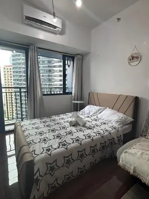 a bedroom with a bed and a large window at Air Residences in Manila