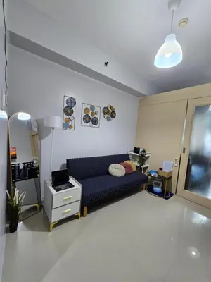 a living room with a blue couch in a room at Sea Residences by Richnell's Staycation 