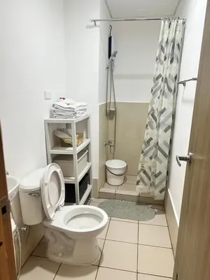 a bathroom with a toilet and a shower at Enchantress Abode in Trece Martires