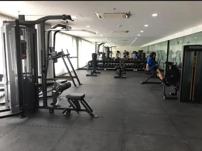 a gym with tread machines and people in the background at Kate's Place in Mall of Asia Complex in Manila