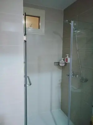 a bathroom with a shower with a glass door at 81 Newport Boulevard-Hyuna Place, Across NAIA T3 in Manila