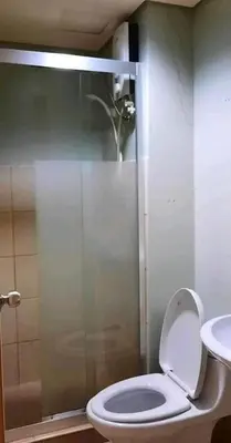 a bathroom with a shower with a toilet and a sink at Avida San lorenzo Tower 1 Studio in Manila