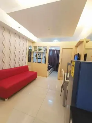 a living room with a red couch and a table at Sea Residences Karen's Staycation in Manila