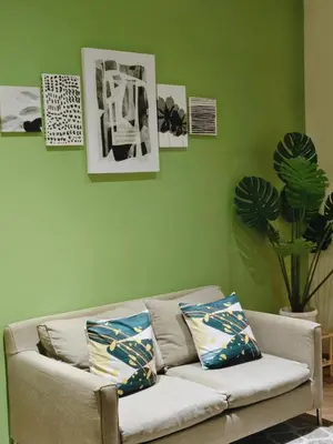 a couch in a living room with green walls at Christine Suites PH 1BR with Balcony Gramercy Residences Makati in Manila