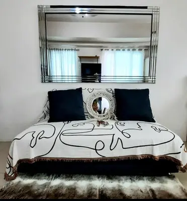 a bedroom with a bed with a large mirror at ApartHotel Tower22307 in Manila
