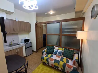 a small living room with a couch and a kitchen at Cozy Home beside mall,MRTBoniEDSA in Manila