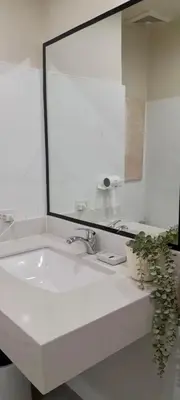 a bathroom with a sink and a large mirror at La Nobleza Manila in Manila