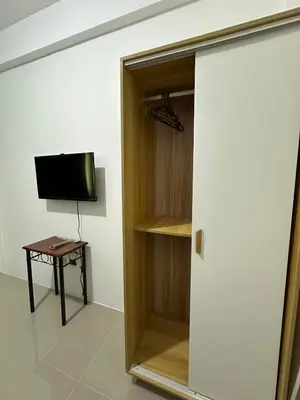 a room with a closet with a television and a table at B&CH RESIDENCE Transient in Calamba