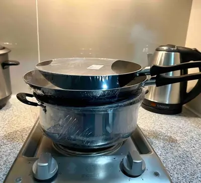 two pans sitting on top of a stove at Condo at the heart of BGC located at Uptown Parksuites in Manila