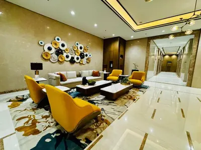 a large living room with yellow chairs and a couch at 10F Luxury 1BR at Park Mckinley West near Venice Mall in Manila